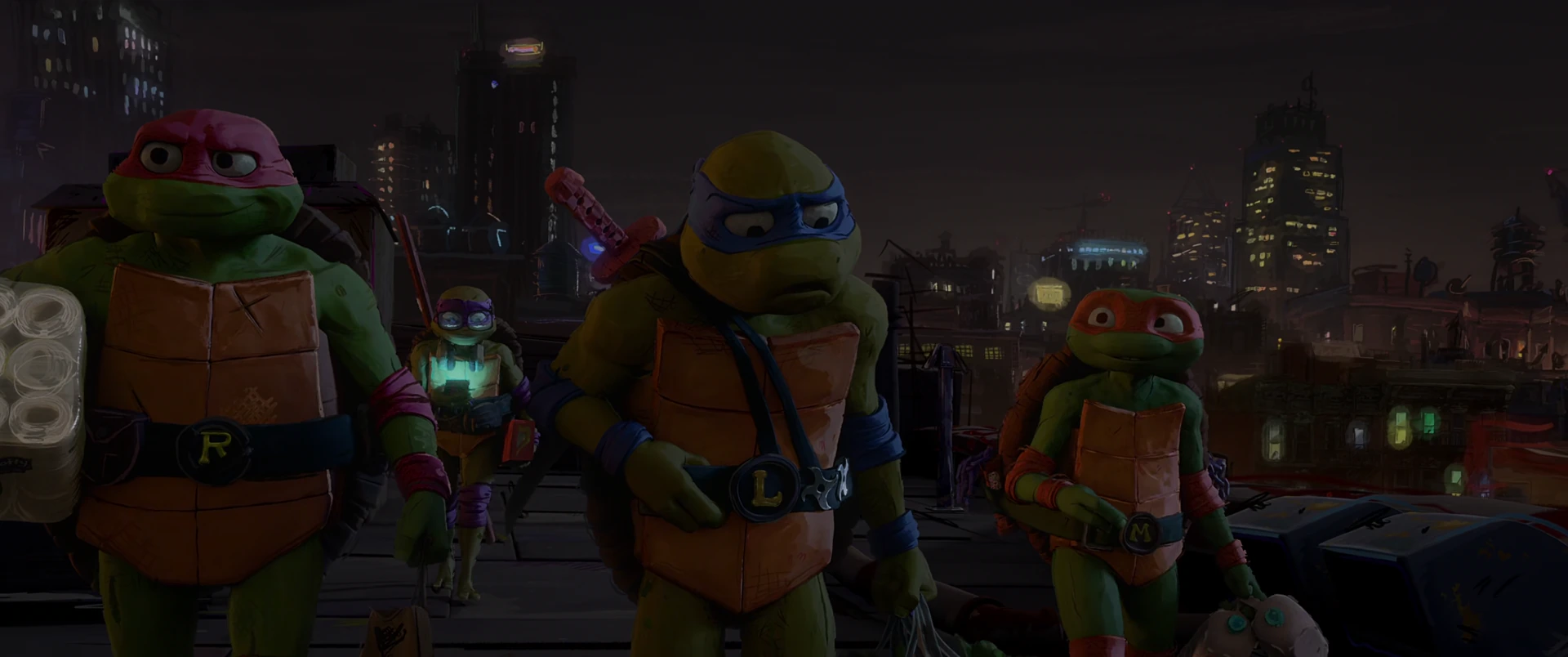 All four Turtles walk shoulder to shoulder across a rooftop at night, colored masks identifying each brother against the city glow.