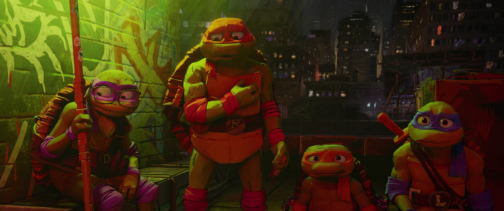 The four Turtles stand proudly upright in green and red light, Raphael chest out and grinning, city skyline behind them.