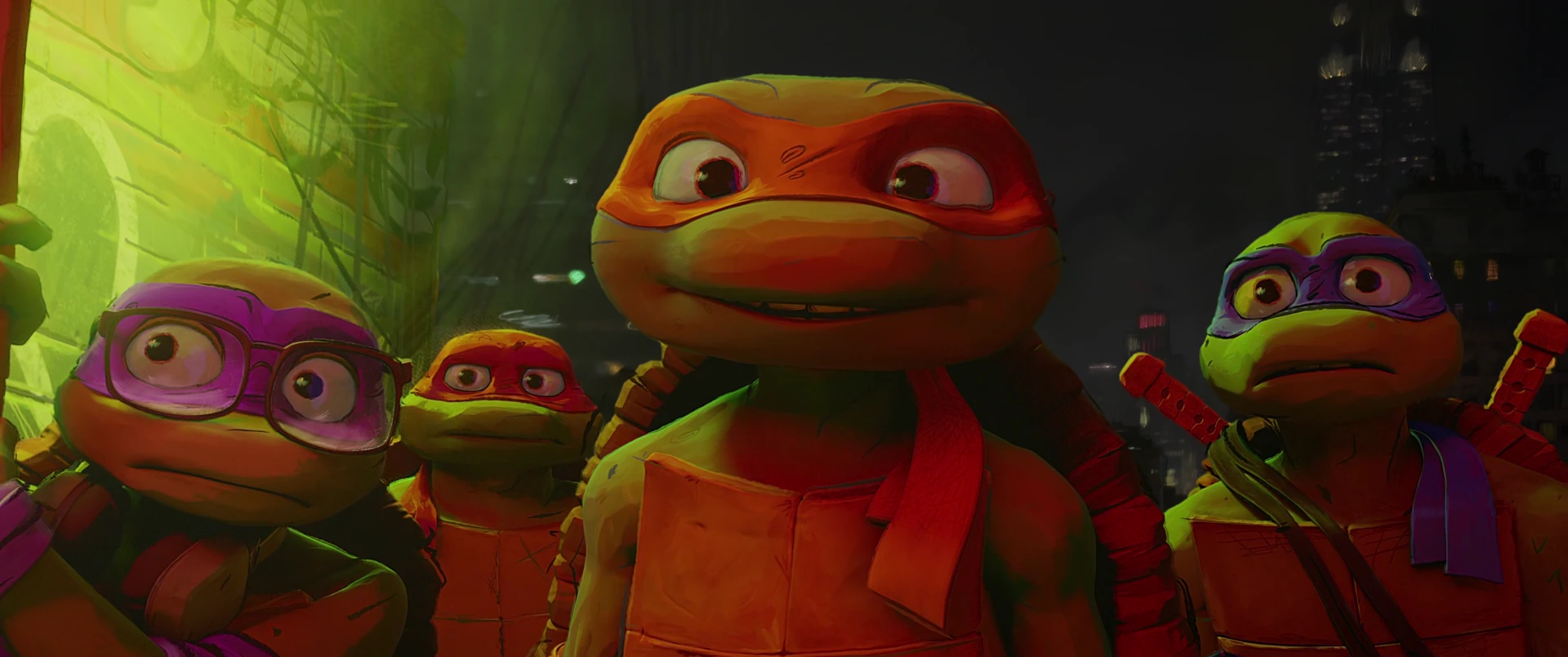 All four Turtles look upward with wide, hopeful eyes under green-tinted street light at night.