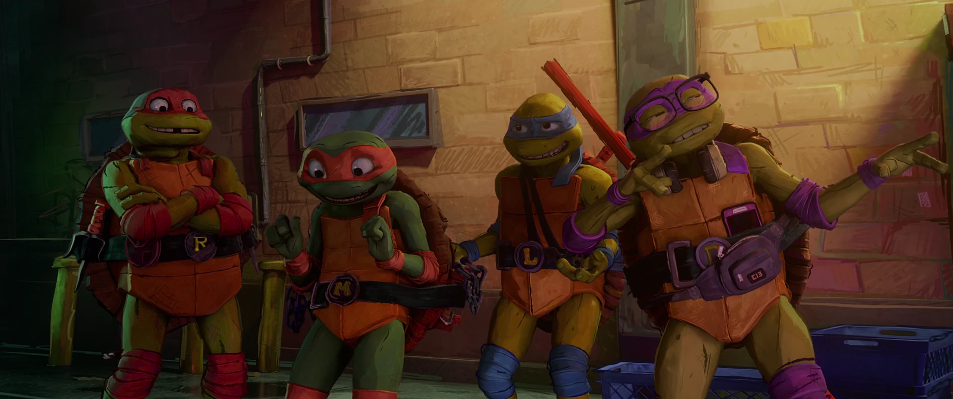 All four Turtles stand shoulder to shoulder against a brick wall, weapons ready, lit by warm amber street light.
