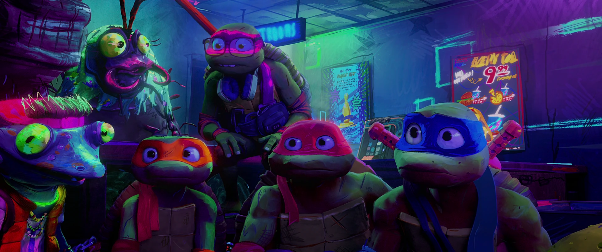 All four Turtles crowd with Genghis Frog in a vibrant neon-purple arcade hideout, faces alert and engaged.