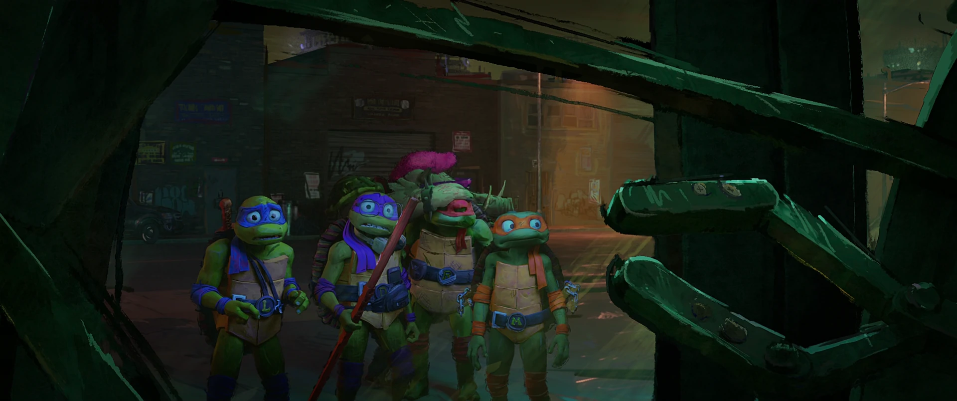 All four Turtles peer cautiously through a gap in a large metal structure on a gritty nighttime NYC street.