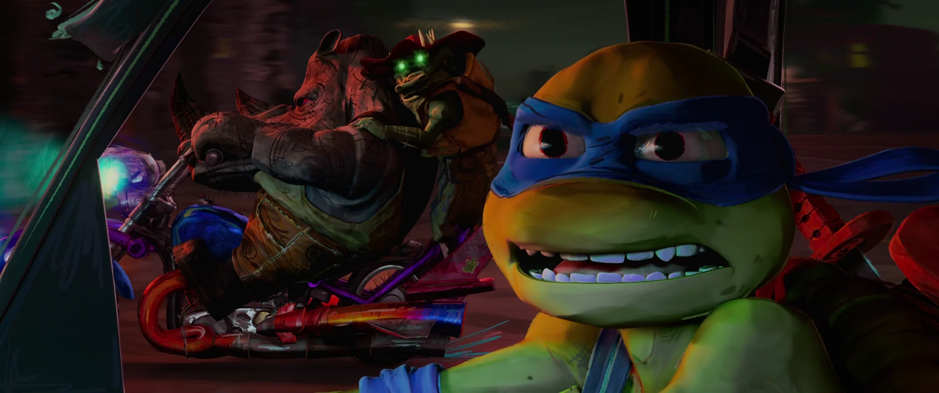Leonardo grimaces in close-up as Superfly looms behind him with glowing green eyes inside a dim vehicle.