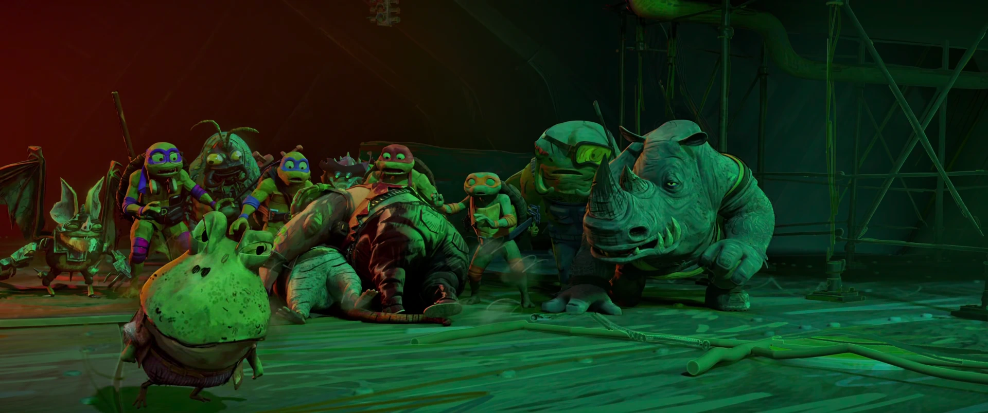 The Turtles and mutant gang crouch together on the hideout floor under green light, Wingnut at left.