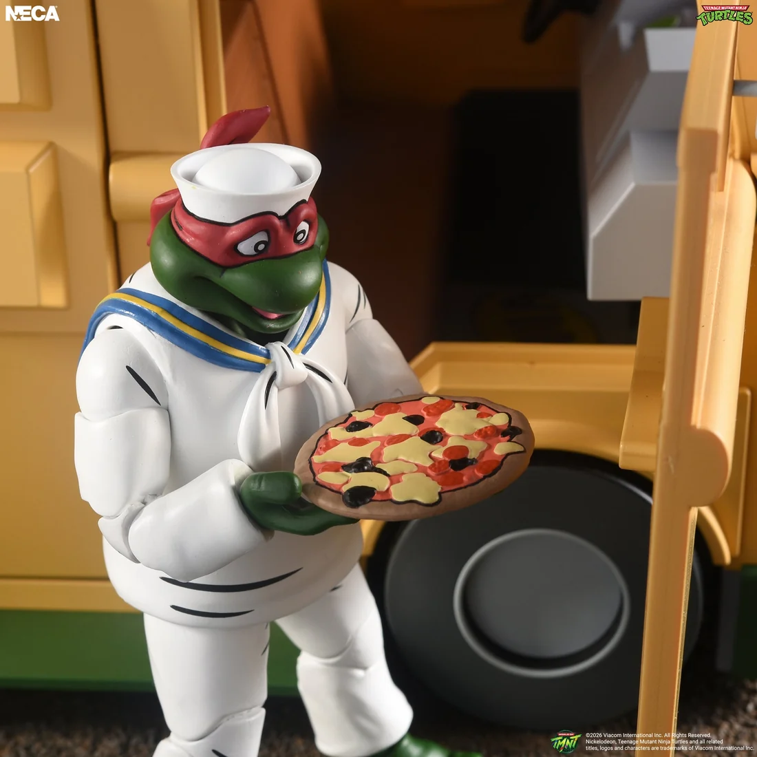 Sailor Raph in a white sailor suit and cap holds a pizza at the open side of the Turtle Van.